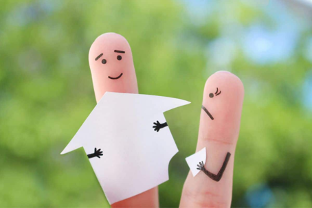 to fingers with smileys holding a broken home.