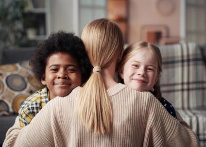 mother hugging two children